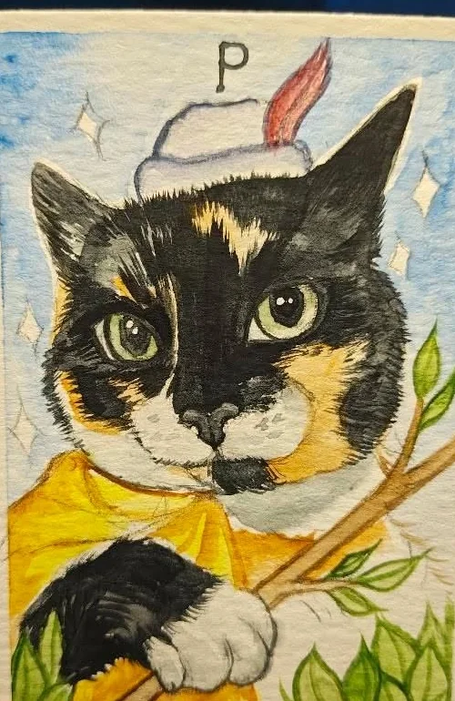 A hand painted tarot card lettered P, a calico cat in a yellow cloak and a plumed cap, holding a green branch
