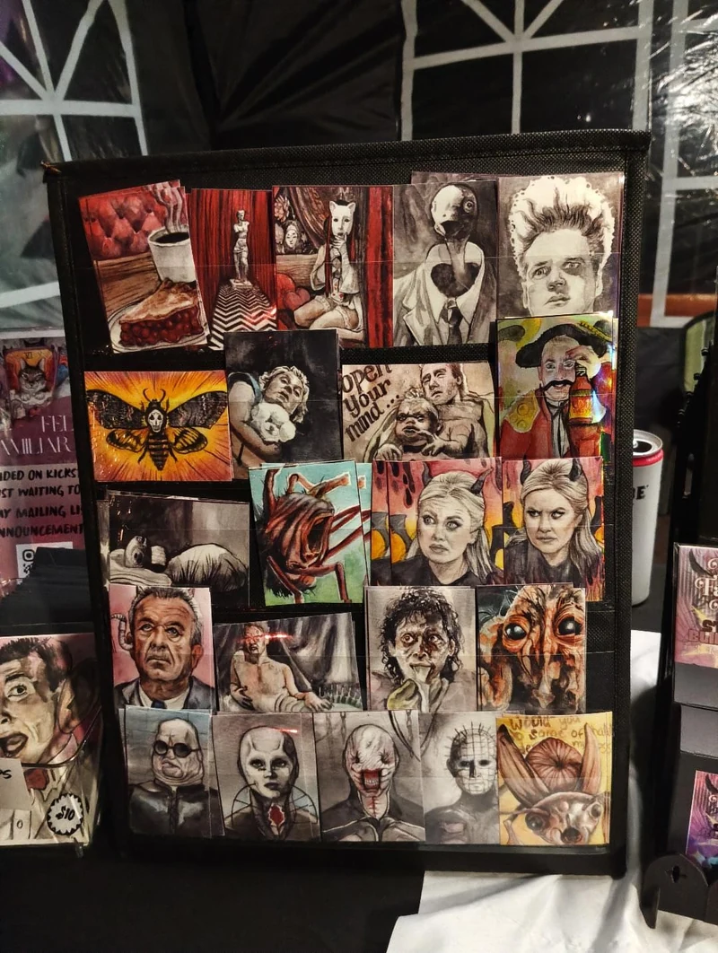 A black rack filled with Sara’s colorful character and horror artwork at the market booth